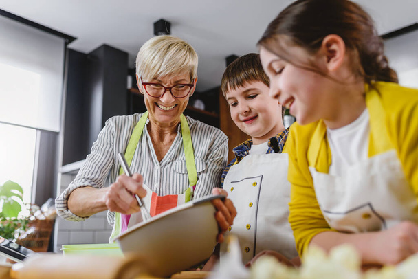 granny with grandchildren preparing cookies - Foto, immagini