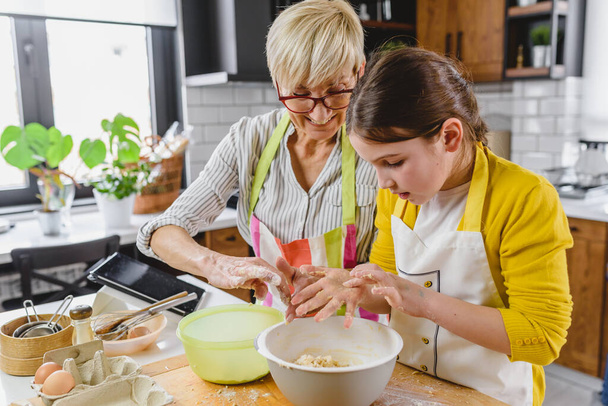 granny with granddaughter making cookies - 写真・画像