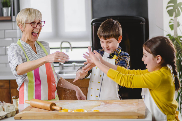 nagyi unokákkal sütit készít - Fotó, kép