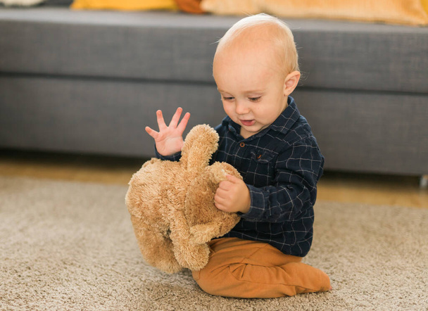 Bambino che gioca con l'orsacchiotto. Ragazzino che abbraccia il suo giocattolo preferito - Foto, immagini