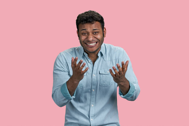 Junger arabischer Mann lacht zähneknirschend über etwas Lächerliches. Vereinzelt auf rosa Hintergrund. - Foto, Bild