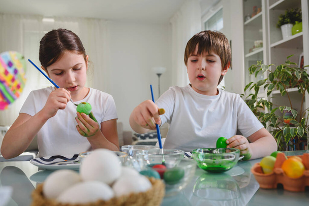 брат и сестра готовятся к эфиру, расписывая яйца - Фото, изображение
