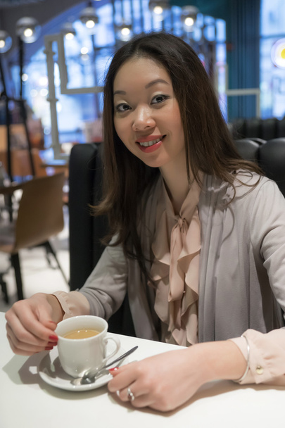 Afable hermosa mujer coreana con una taza de café
. - Foto, imagen