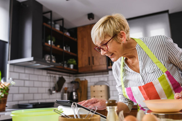 Frau benutzt Tablet in Küche  - Foto, Bild