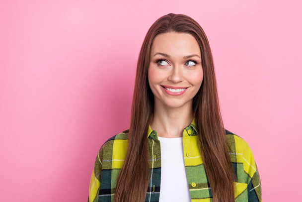 Photo of pleasant gorgeous girl with long hairstyle dressed checkered shirt look at offer empty space isolated on pink color background. - Fotó, kép