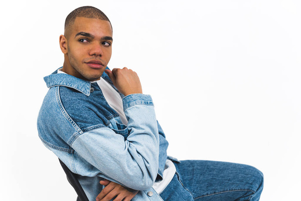 Modelo masculino confiante pensativo na jaqueta jeans olhando para trás e fazendo uma pose pensante. Fundo branco. Tiro no estúdio. Foto de alta qualidade - Foto, Imagem