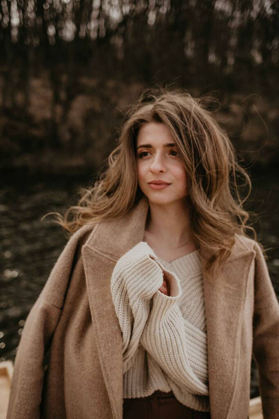 Portrait of a woman in a coat by the water. - Photo, Image