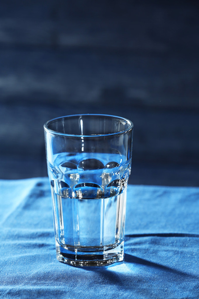 Glass of water on table on wooden background - Foto, imagen
