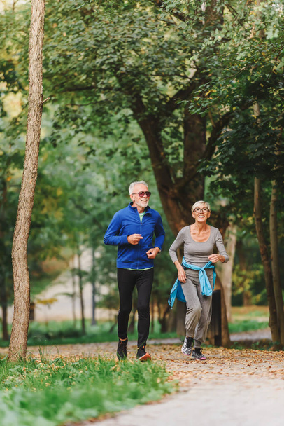 senior paar joggen in het park  - Foto, afbeelding