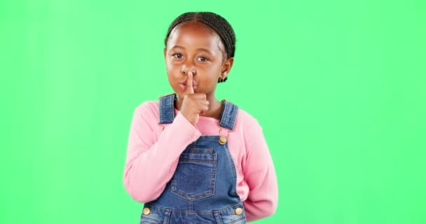 Face, secret and black girl with finger on lips, silence and happiness against studio background. Portrait, African American female child and young person with gesture for quiet, kid and green screen. - Footage, Video