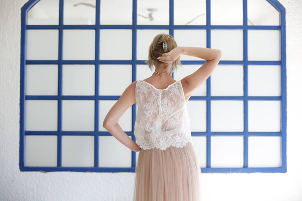Fashion portrait of woman in white lace top in front of traditional blue greek style windows - Photo, Image