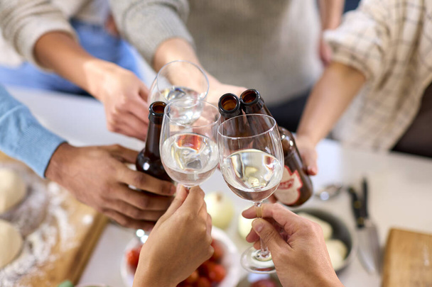 Close Up Of Friends Celebrating With Cheers At Home In Kitchen Making Food For Party - Photo, Image