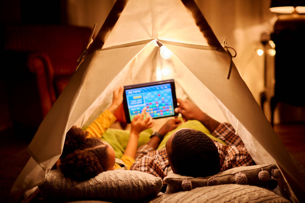 Father And Daughter At Home Lying In Indoor Tent Or Camp Gaming On Digital Tablet - Zdjęcie, obraz