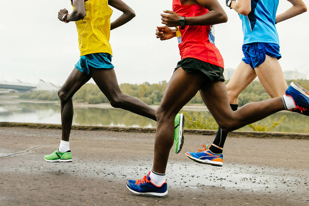 Gruppe afrikanischer und europäischer Läufer beim Marathonlauf, Beine Jogger beim Weltmeisterschaftslauf - Foto, Bild