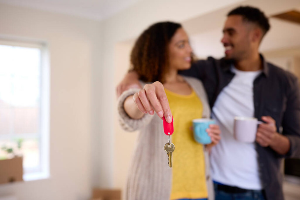 Excited Couple Unpacking Boxes Holding Keys To New Home On Moving Day - Fotoğraf, Görsel