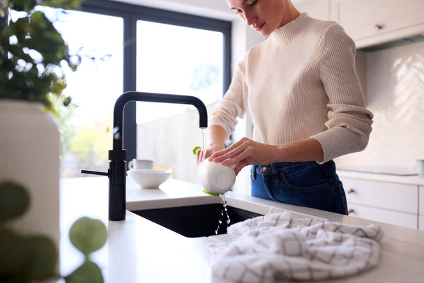 Close Up Of Woman At Home In Kitchen Doing Washing Up - Foto, afbeelding