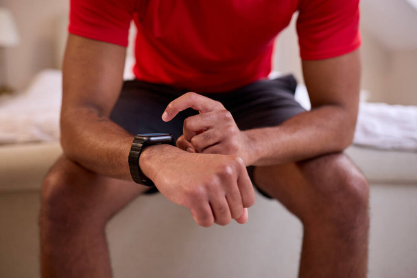 Close Up Of Man At Home In Fitness Clothing Checking Fitness App On Smart Watch Before Exercise - Photo, Image