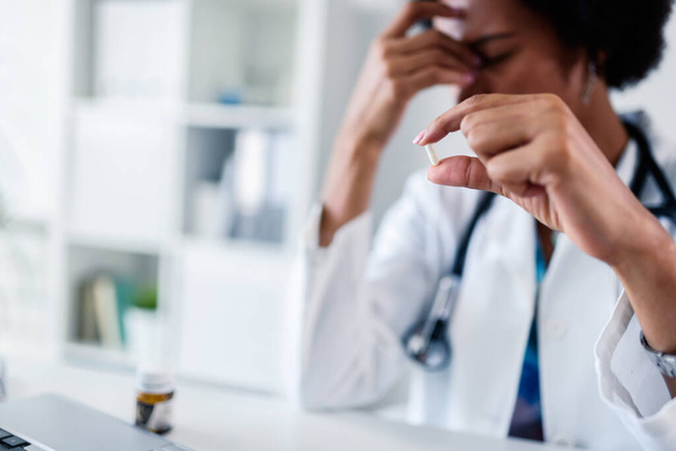 Gestresste Ärztin nimmt Tablette in ihrem Büro - Foto, Bild