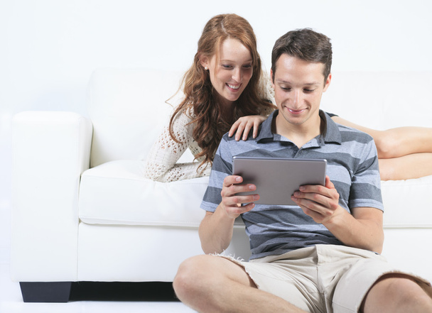 A beautiful Couple on sofa with digital tablet - Foto, afbeelding