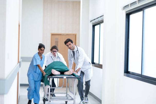 Doctors, Nurses, and Paramedics pushing stretcher gurney bed with seriously injured patient towards the operating room. Professional Staff Saving Lives. Health care Concept - Photo, Image
