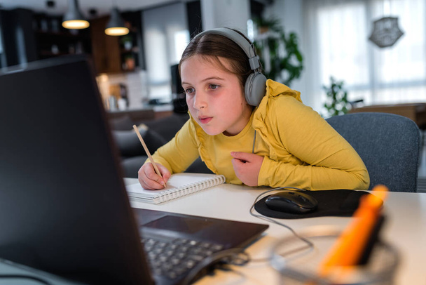 девочка использует свой ноутбук во время учебы, онлайн-образование - Фото, изображение