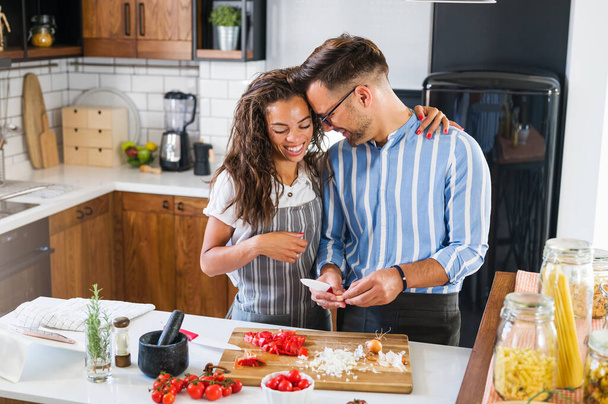 beautiful young couple in love in the kitchen cooking together - Photo, Image