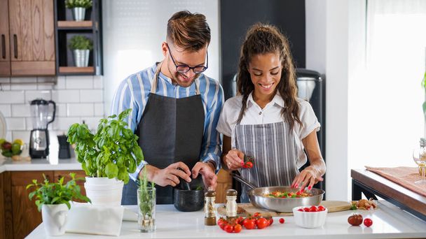 beautiful young couple in love in the kitchen cooking together - Photo, Image