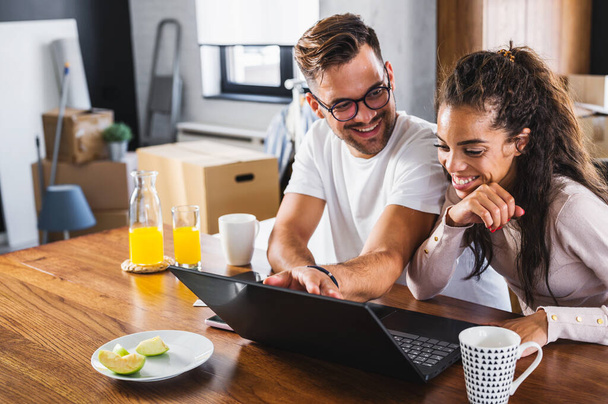 uomo e donna guardando qualcosa sul computer portatile mentre stanno facendo colazione - Foto, immagini