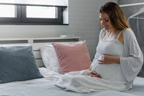Mulher grávida na cama
  - Foto, Imagem
