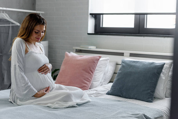 Zwangere vrouw in bed  - Foto, afbeelding