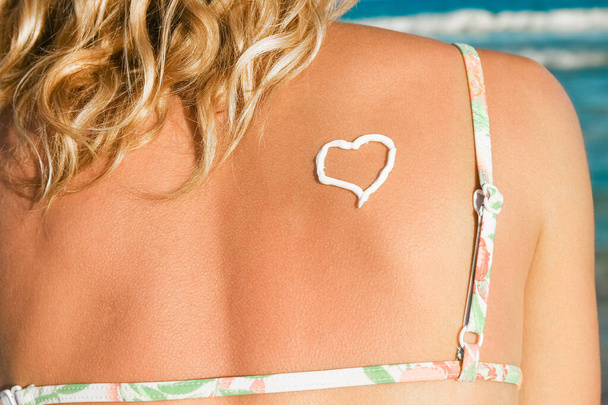 happy girl with a heart on her back by the sea outdoors - Foto, Bild