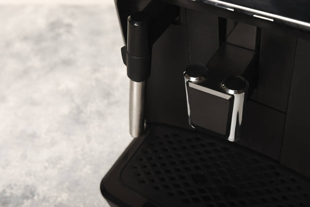 Moderne koffiezetapparaat met kopje in keuken close-up interieur. Hete sterke aromatische espresso. Goedemorgen koffie. Espresso machine op een houten tafel. ruimte voor tekst. kopieerruimte. - Foto, afbeelding