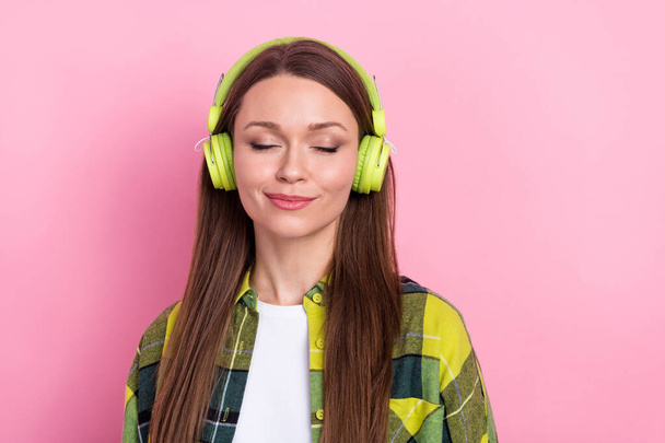 Photo of peaceful carefree woman with long hairstyle checkered shirt eyes closed enjoy favorite songs isolated on pink color background. - Foto, Bild