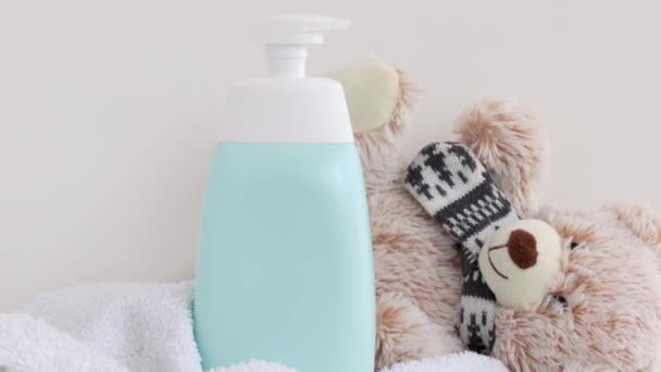 σαμπουάν ντους τζελ σαπούνι μπουκάλι με δοχείο στην πετσέτα μπάνιου με μαλακό σχήμα κουκουβάγια παιχνίδι ή αρκουδάκι. μωρό νήπιο νεογέννητο έννοια φροντίδας, καθημερινό προϊόν δεν διαφήμιση μάρκα αντίγραφο πάστα ελεύθερο χώρο - Πλάνα, βίντεο