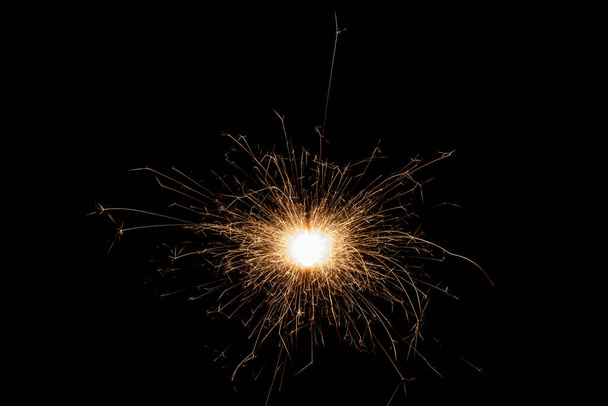 Burning sparkler isolated on black background. Fireworks theme. Light effect and texture. Christmas and new year decoration. - Фото, изображение