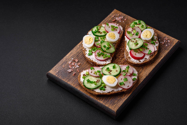 Lezzetli sandviç ya da krem peynirli turp ve koyu betondan yapılmış yeşil soğanlı bruschetta. - Fotoğraf, Görsel