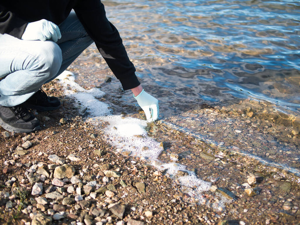 Person collecting contaminated water samples for laboratory analysis. Concept contamination, analysis, environment. - Photo, Image
