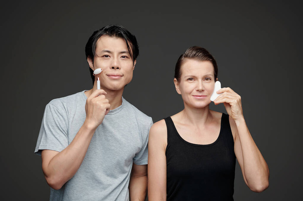 Různorodý pár dělá každodenní masáž obličeje proti vráskám - Fotografie, Obrázek
