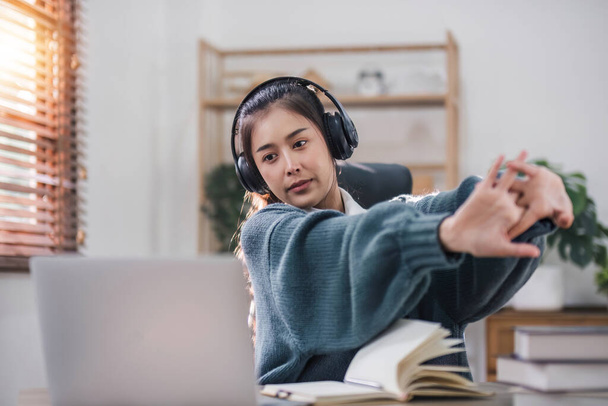 Sıkıcı Asyalı kız öğrenci ders çalışıyor, dizüstü bilgisayara bakıyor, sıkıcı online derslere katılıyor ya da konferanslara katılıyor. Sıkılmış tembel.. - Fotoğraf, Görsel