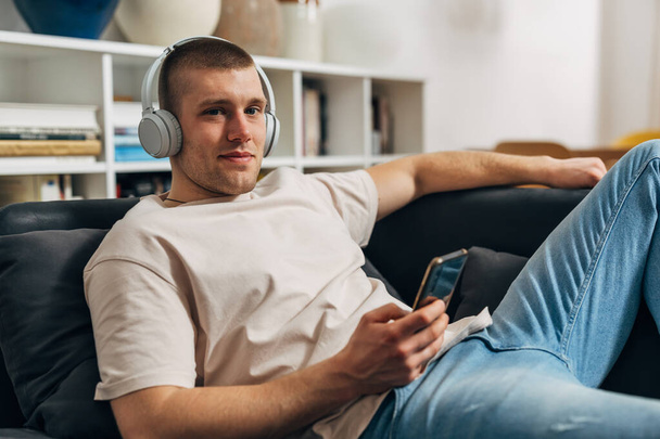 A Caucasian man is listening to music at home in his free time - Foto, Bild