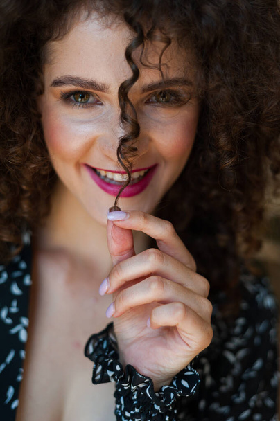 portrait of a beautiful young woman with curly hair and a red lips - Фото, изображение