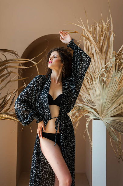 beautiful young woman in black lingerie posing in studio - Фото, изображение