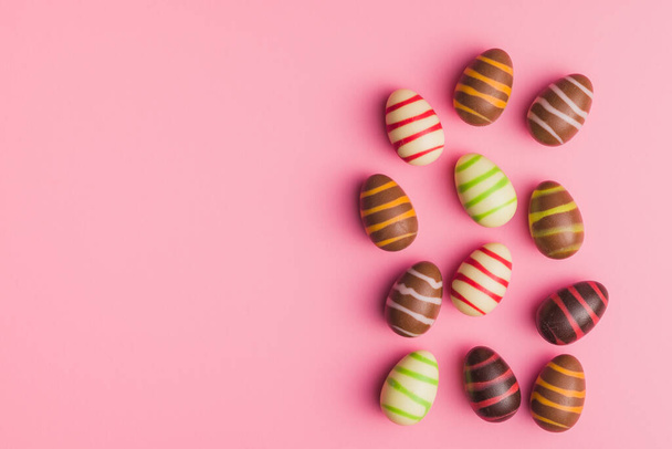 Chocolate easter eggs on the pink background. Top view. - 写真・画像