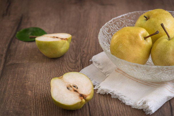 Peras frescas maduras en un bol sobre un fondo de madera. Frutas de verano - Foto, imagen