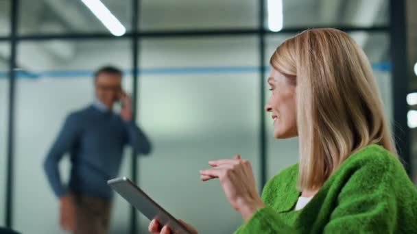 Smiling woman waving to partner at hall portrait. Positive boss watching tablet sitting armchair at lounge closeup. Unknown man colleague greeting to business lady at lobby zone. Corporate lifestyle - Footage, Video