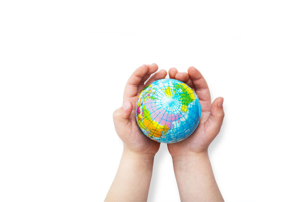 Milieu voor de toekomst, red het planeet concept. Wereldbol in kinderhanden bovenaanzicht met kopieerruimte. - Foto, afbeelding