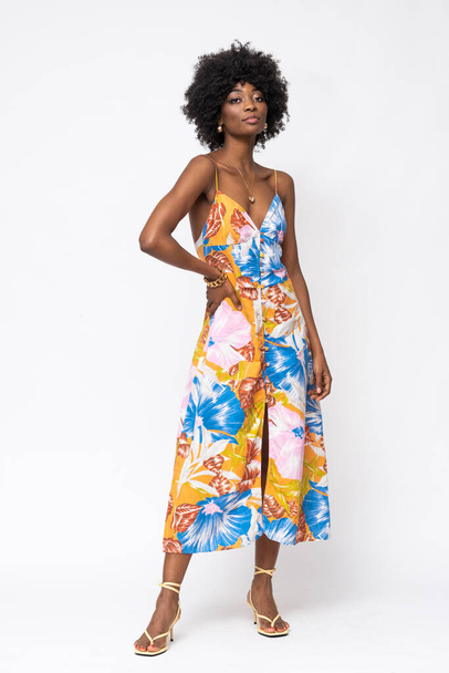 Fashionable African woman with curly hairs and floral dress on isolated white background. - 写真・画像