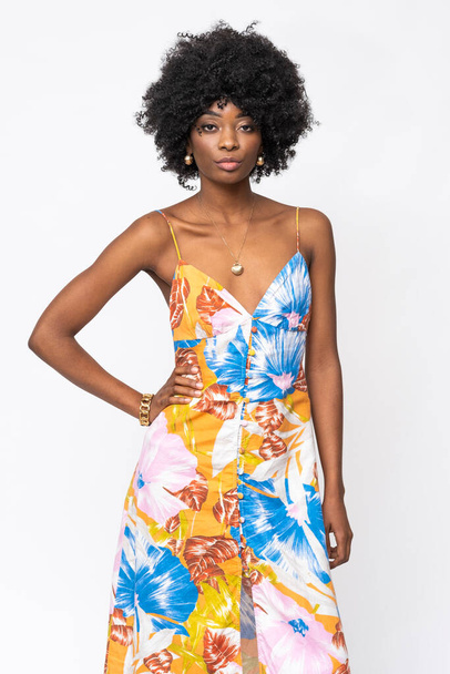 Fashionable African woman with curly hairs and floral dress on isolated white background. - Photo, Image