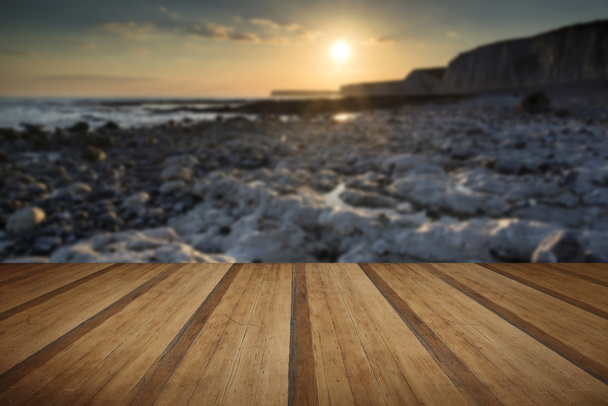 Paisagem de exposição longa costa rochosa ao pôr do sol com pl de madeira
 - Foto, Imagem