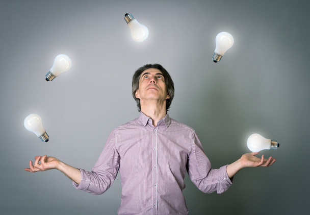 Чоловік жонглює з лампочками
 - Фото, зображення